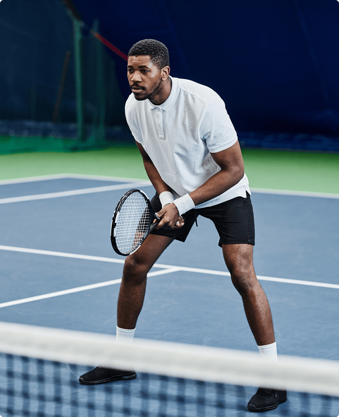 Adult tennis player at the net in the ready position