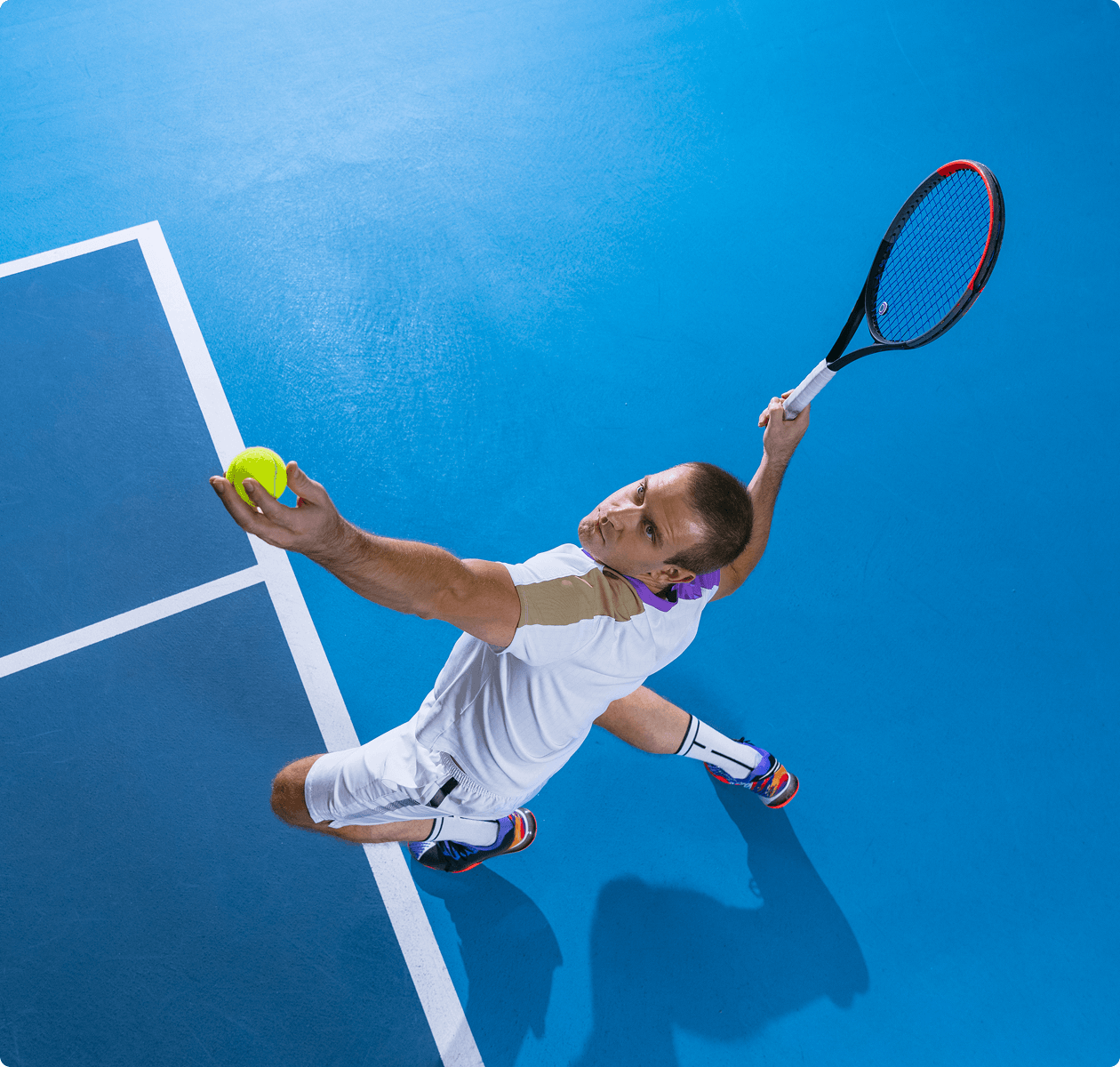 Tennis player serving on blue court.