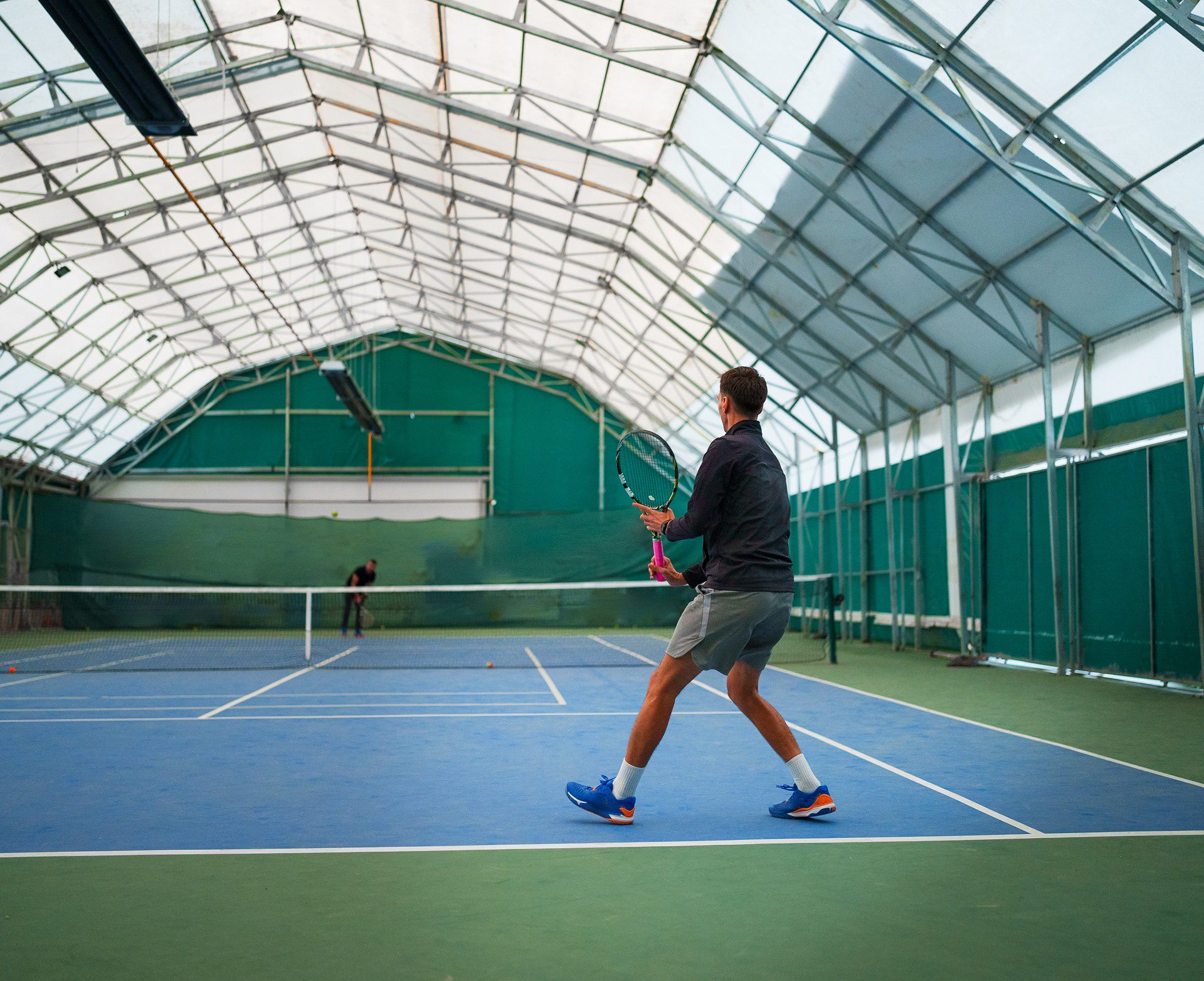 Indoor tennis match with two players competing.