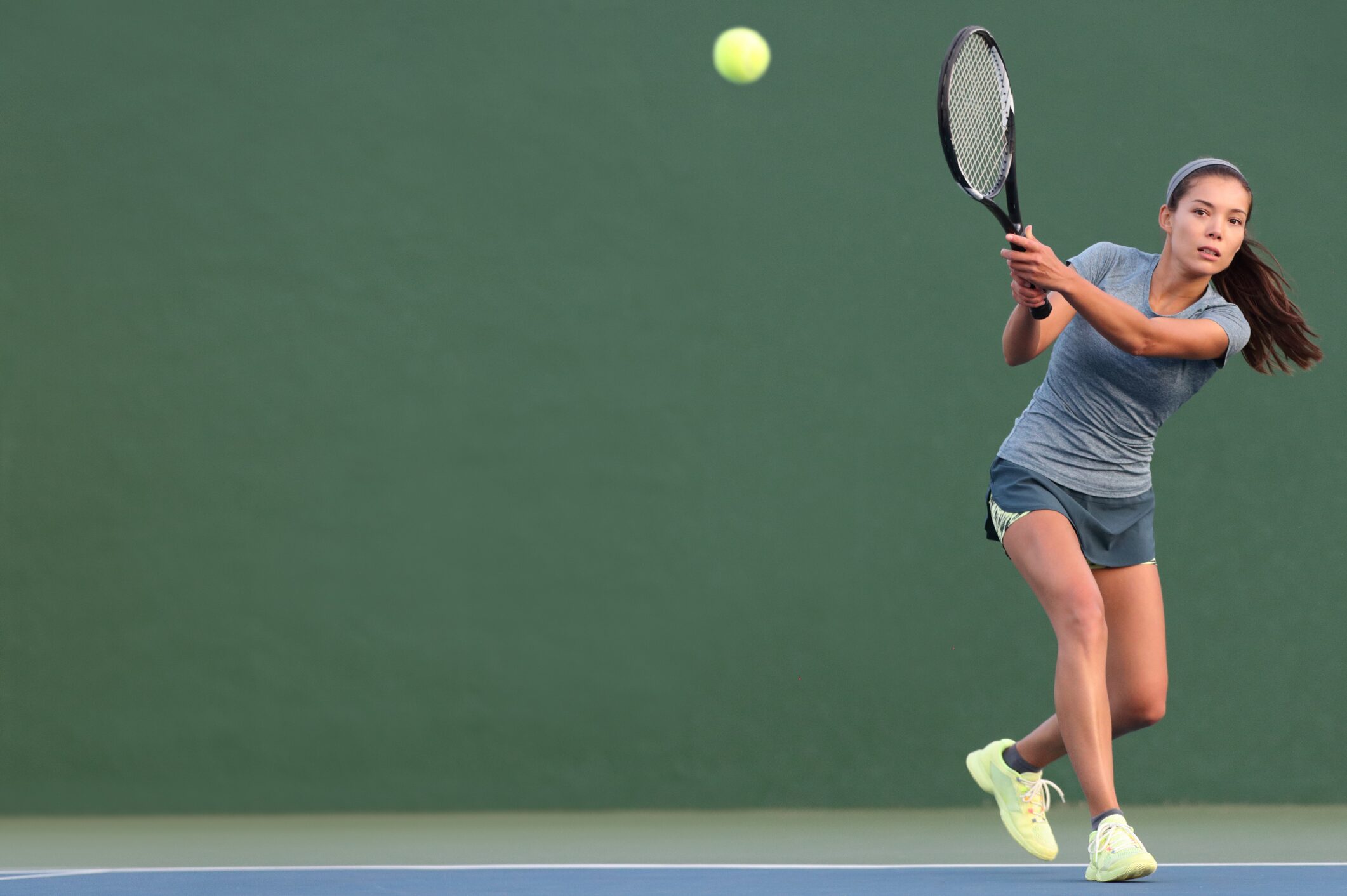 Female Tennis Player hitting a backhand